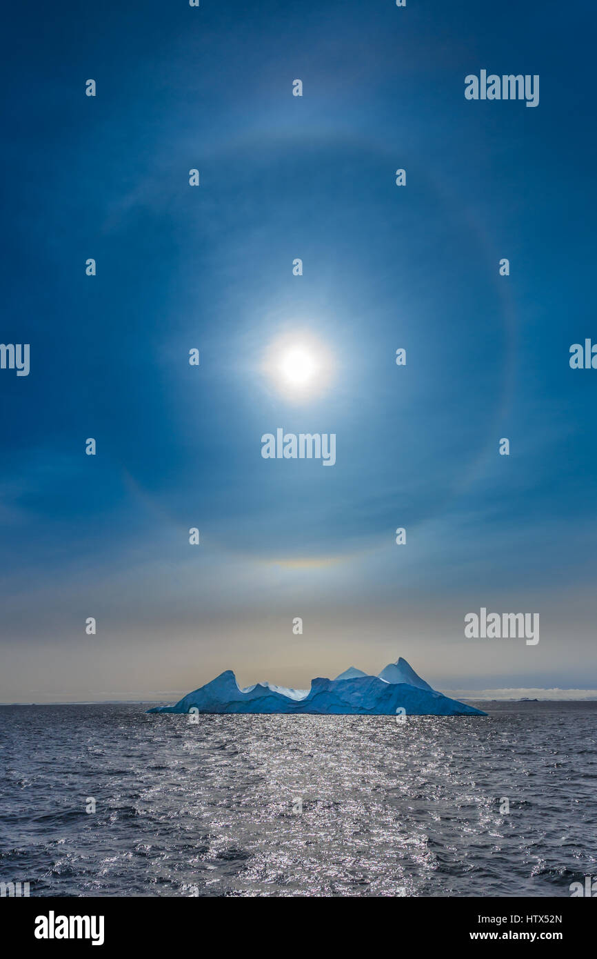 Sun Halo shining over the blue iceberg and ocean, North Greenland Stock Photo