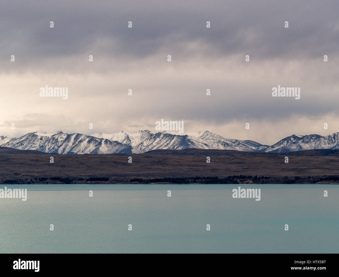 Alpine lake with view of mountains seen over water. Lake Pukaki, Mackenzie Country, South Island,  New Zealand. Stock Photo