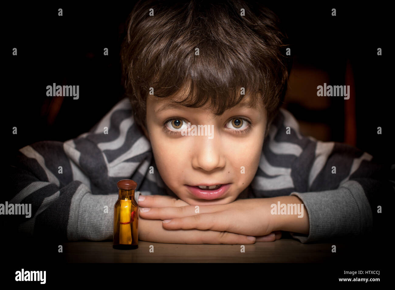 Boy trustful look and his message in a bottle, portrait. Stock Photo