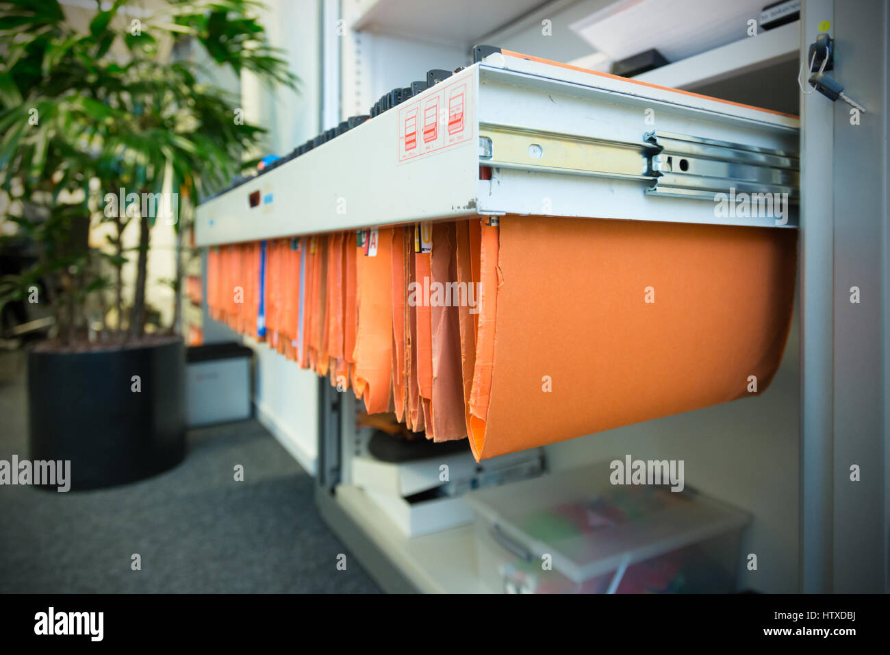 old and used orange paper File Folders in a metal filing cabinet.Cupboard with suspension files Stock Photo
