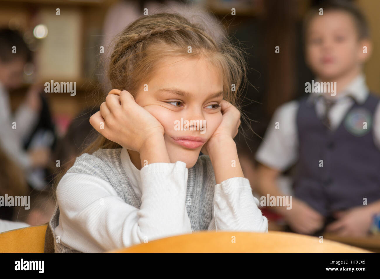 Girl bored at school sitting at a desk on the reverse Stock Photo - Alamy