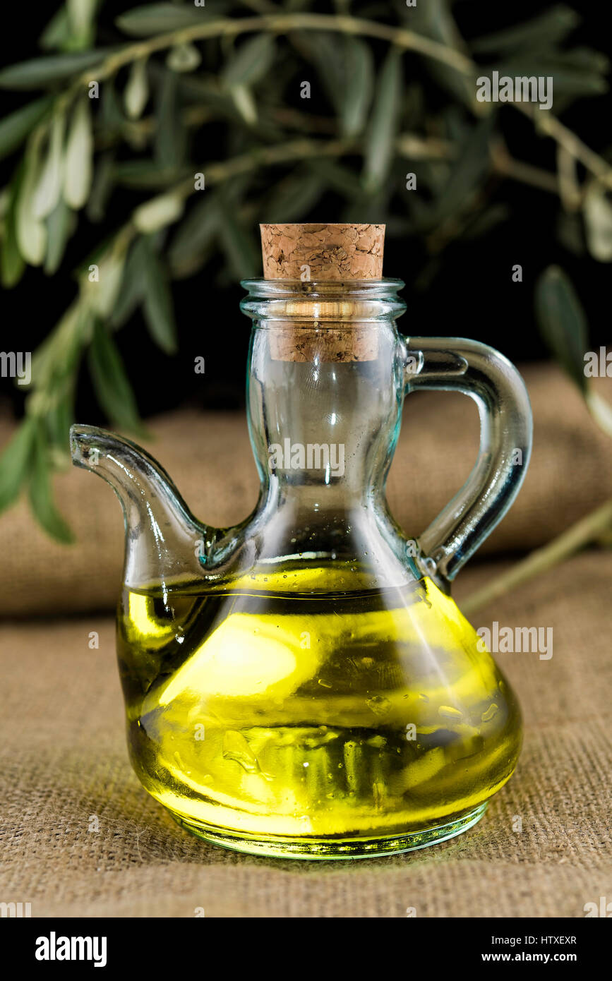 A bottle of extra virgin oil with an olive branch as a background Stock ...