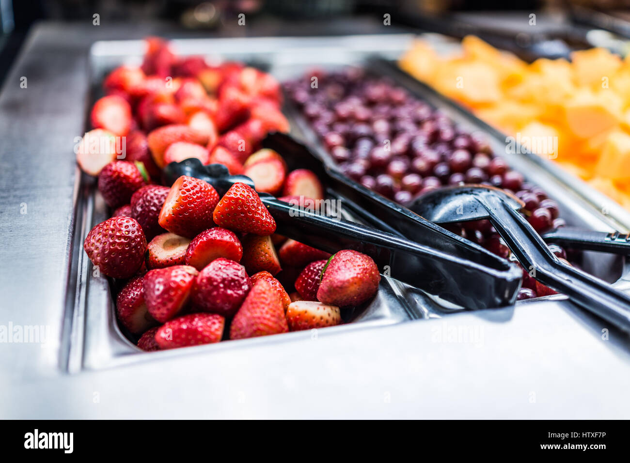 Fruit salad bar with whole strawberries and grapes Stock Photo
