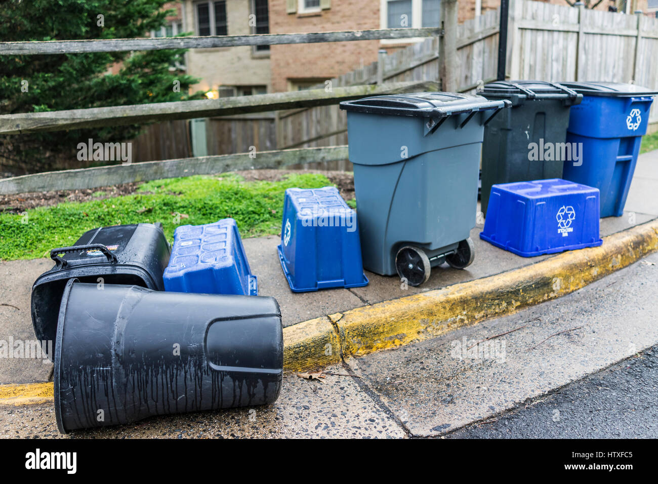 Trash cans outside on curb with recycle bins in neighborhood Stock