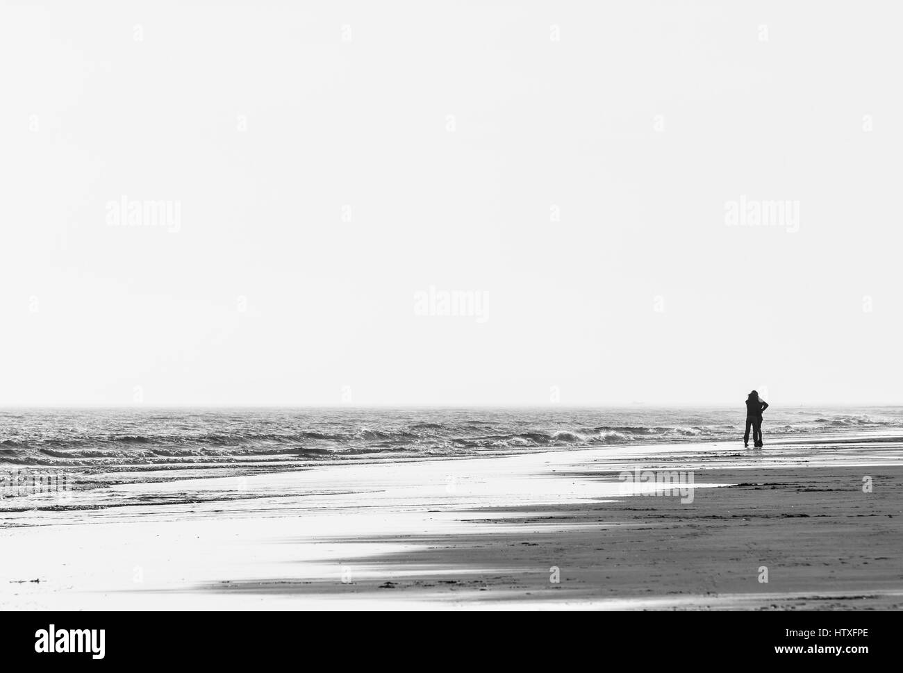 A silhouette of a couple embracing each other on an isolated beach in England Stock Photo