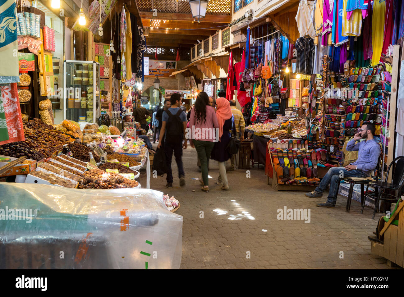 Fes, Morocco.  Street Scene in Fes El-Bali, the Old City.  Dried Fruit, Leather Slippers, Handbags. Stock Photo