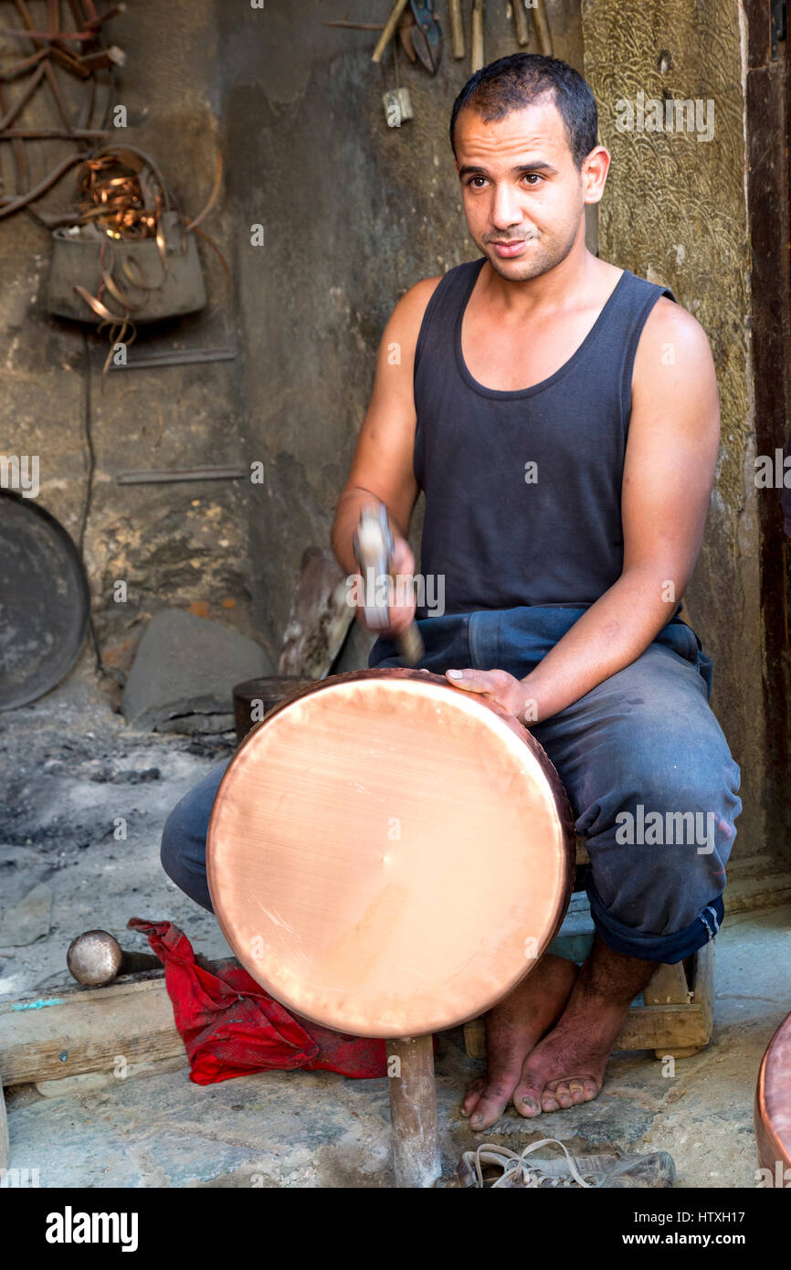 Fes, Morocco.  Metalworker Hammering a Copper Pot in the Seffarine Square (Place Seffarine). Stock Photo