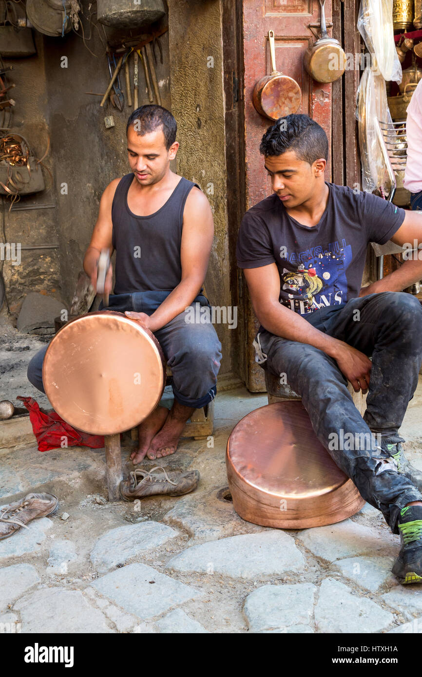 Fes, Morocco.  Metalworker Hammering a Copper Pot in the Seffarine Square (Place Seffarine). Stock Photo
