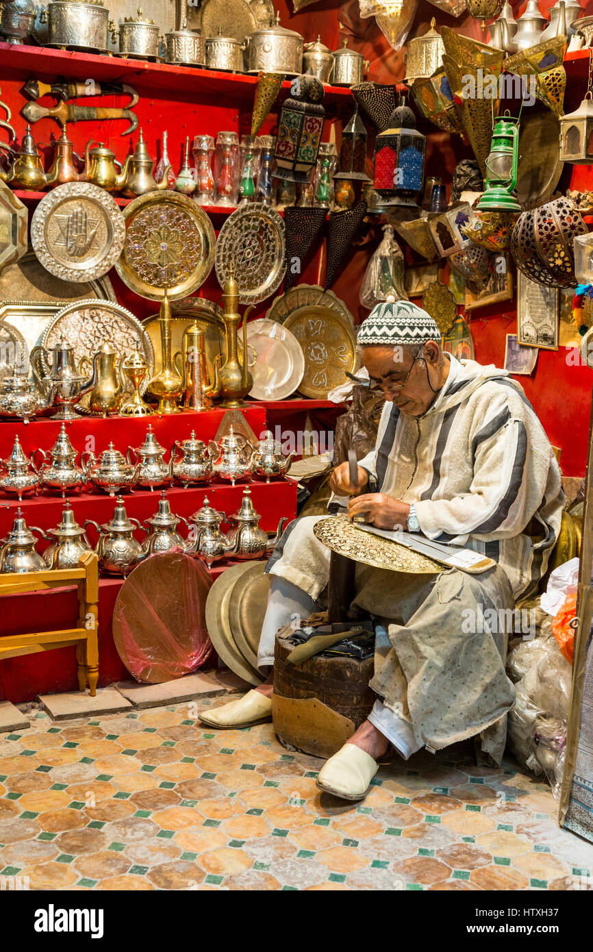 Fes, Morocco.  Metalworker Hammers a Design into a Tray. Stock Photo