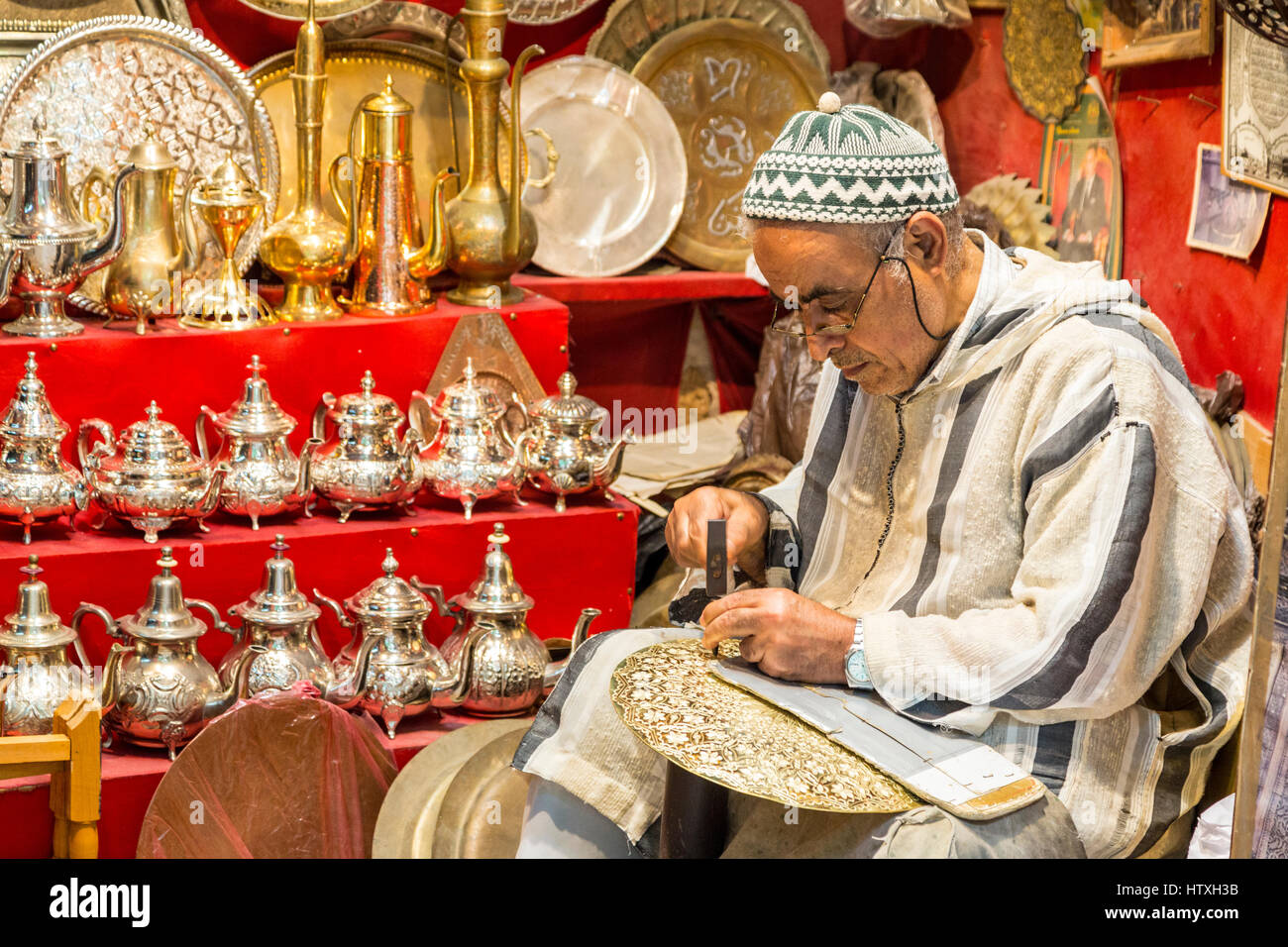 Fes, Morocco.  Metalworker Hammers a Design into a Tray. Stock Photo