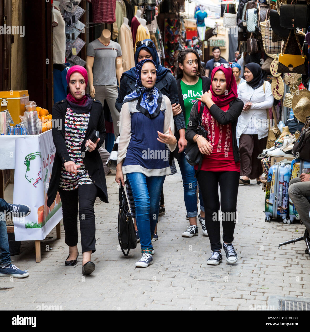 Fes, Morocco.  Young Moroccan Women Walking in  the Medina, Tala'a Seghira Street, Fes El-Bali.  Modern Dress Styles. Stock Photo