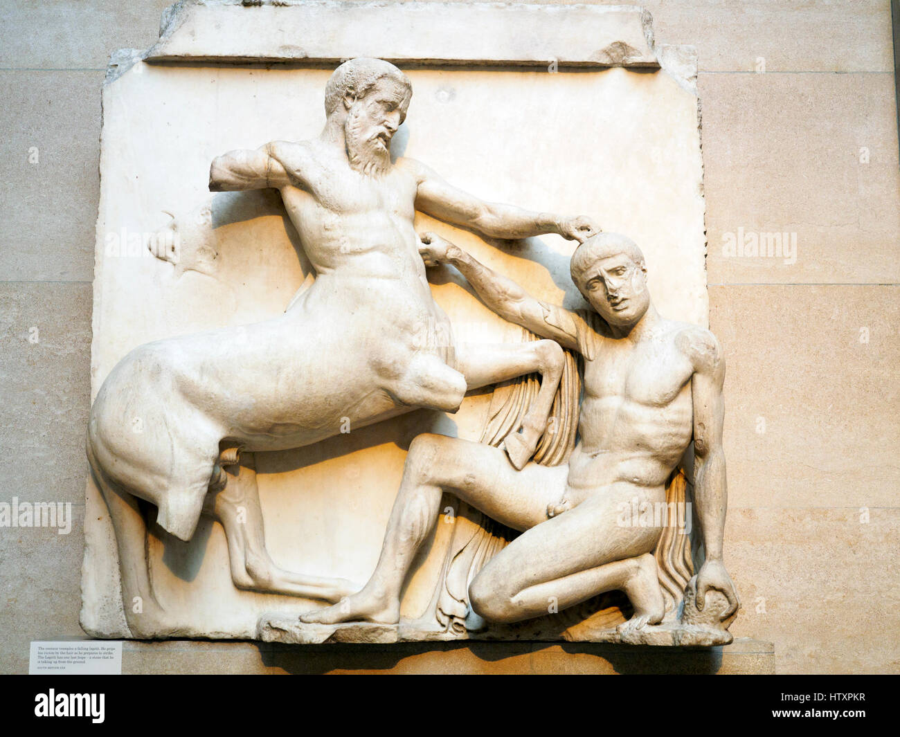 Marble metope from the south side of the Parthenon, showing the battle between Centaurs and Lapiths at the marriage-feast of Peirithoos in the British Museum - London, England Stock Photo