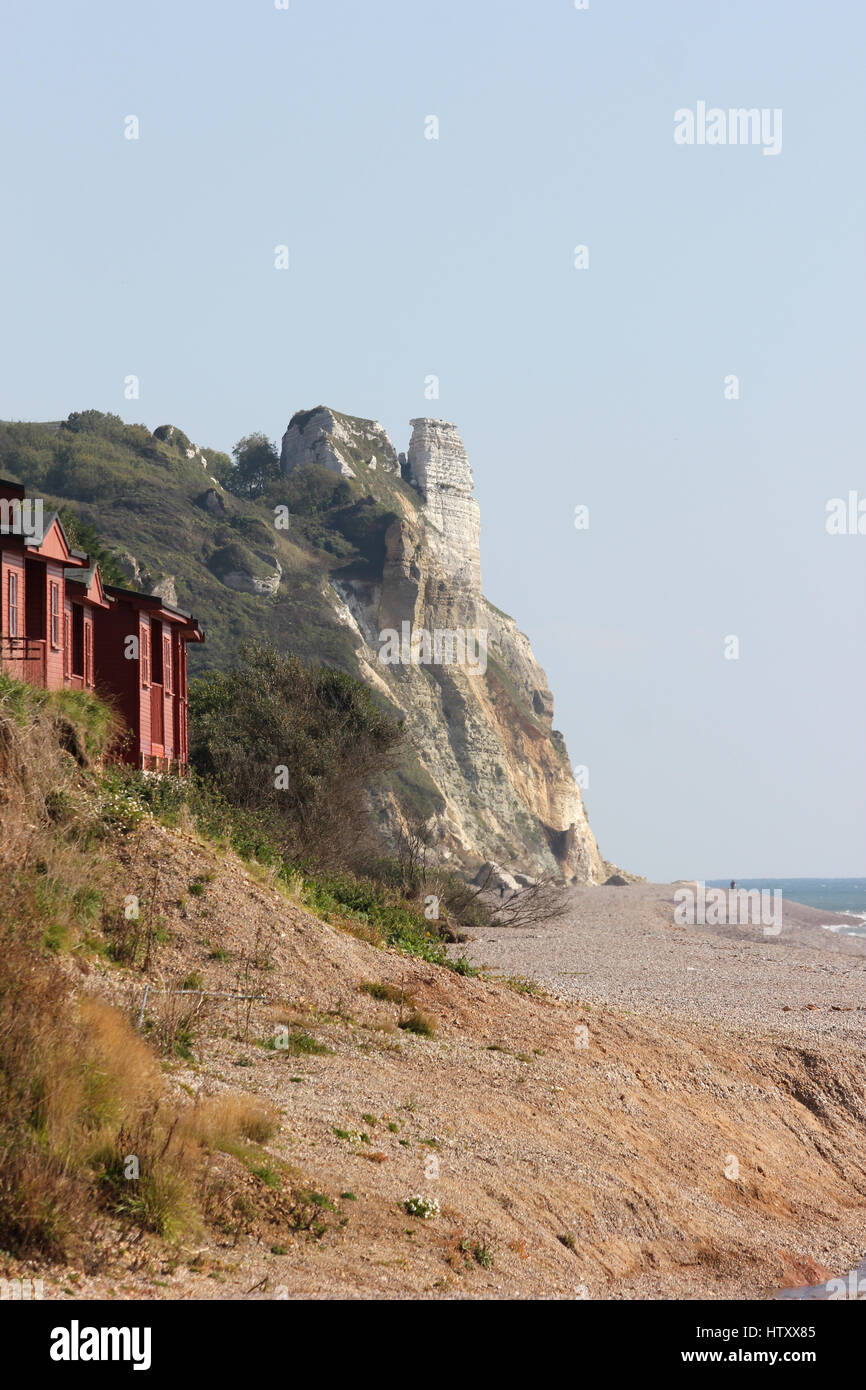 Beach huts and the cliffs between Branscombe and Beer Head, Devon, looking east from Branscombe beach on a sunny day with blue sky Stock Photo