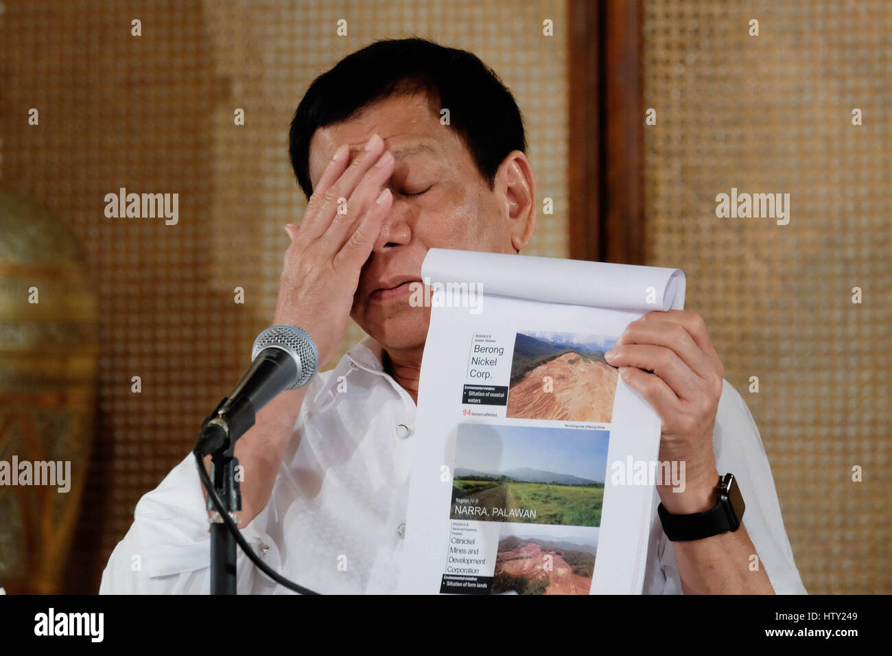 Philippine President Rodrigo Duterte reacts as he holds up a report on environmental damages caused by illegal mining during a press conference at the Rizal Hall at the Malacanang Palace March 13, 2017 in Manila, Philippines. Stock Photo