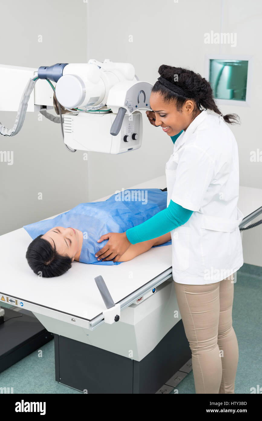 Radiologist Taking X-ray Of Mature Woman Lying On Gurney Stock Photo