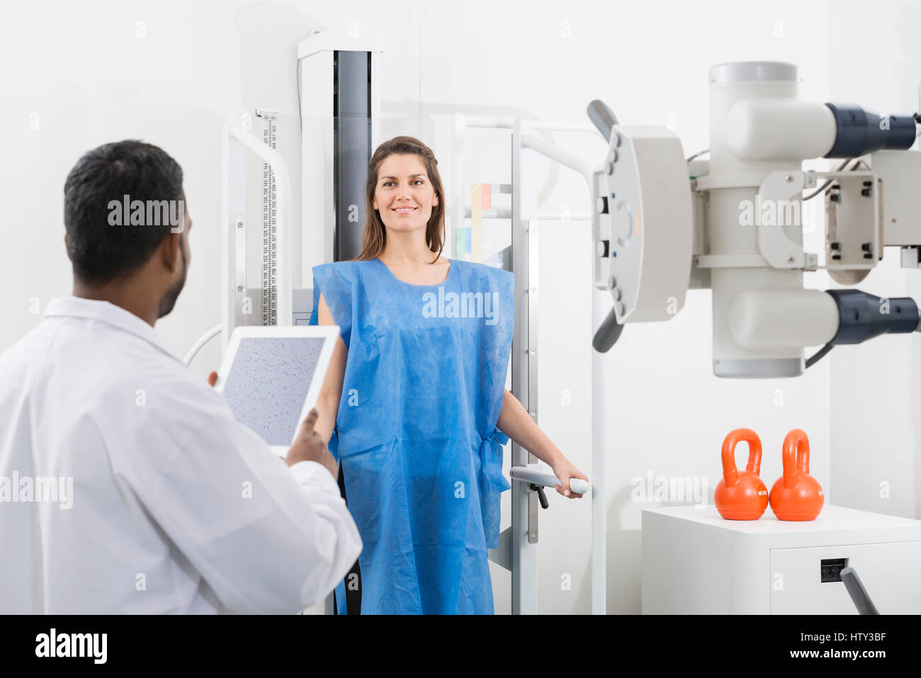 Male Doctor Taking X-ray Of Female Patient In Hospital Stock Photo