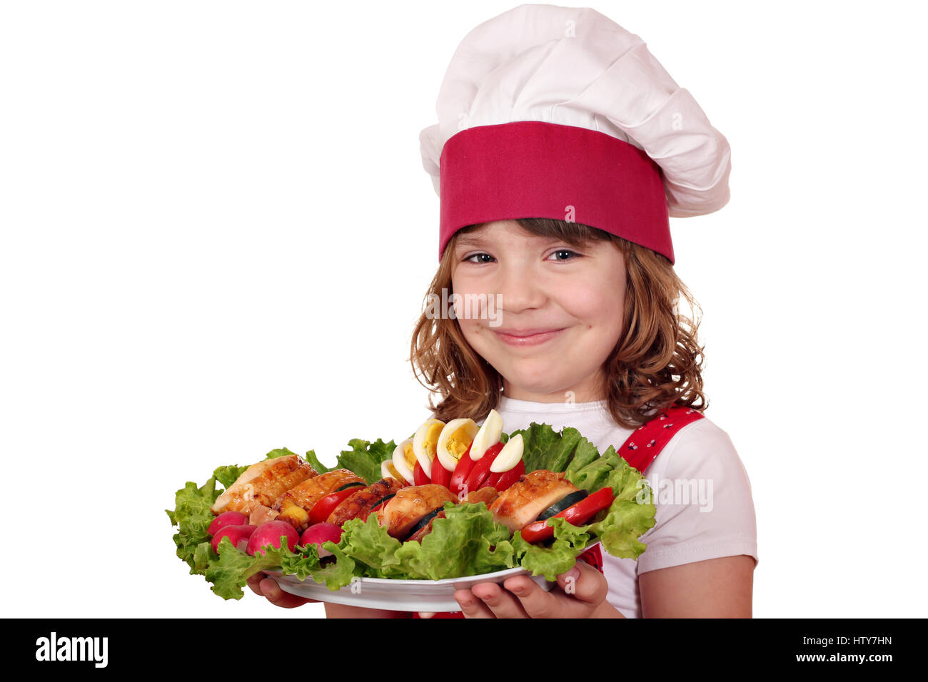 beautiful little girl cook with roasted chicken meat and salad Stock Photo