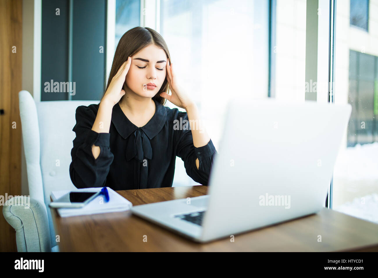 Tired minded woman thinking about way to complete task on laptop at table in cafe Stock Photo