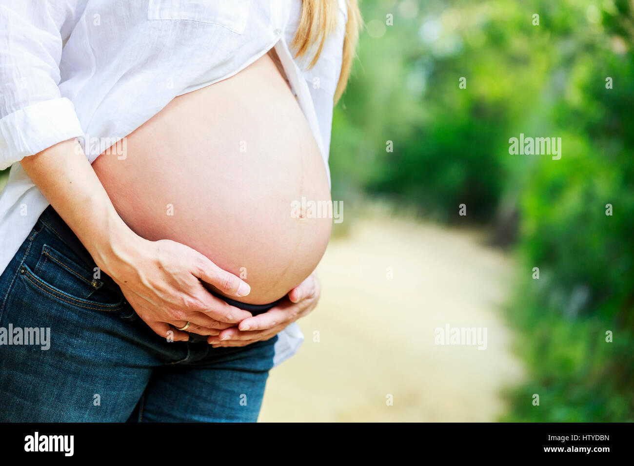 Pregnant woman holding her belly Stock Photo - Alamy