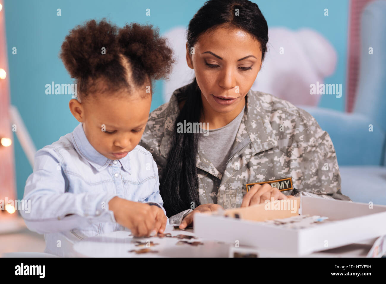 Kind loving mom helping her child with a puzzle Stock Photo