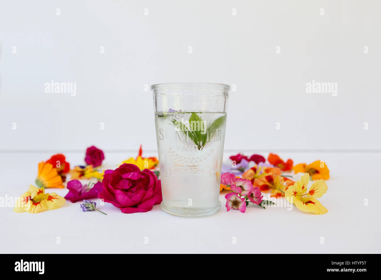 Glass of mint water with edible flowers Stock Photo