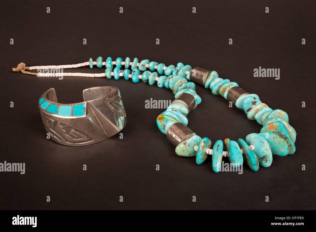 Antique Native American Sterling Silver Hollow-Form Cuff Bracelet with Overlay and Turquoise Inlay, and Large Turquoise Nugget and Silver Necklace. Stock Photo