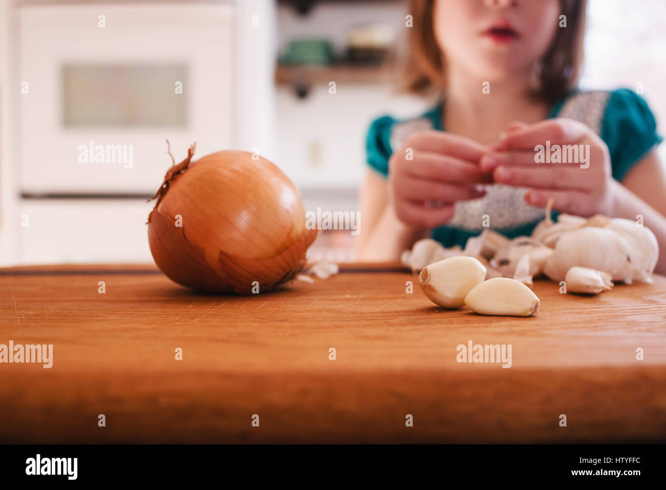 Girl peeling garlic cloves Stock Photo