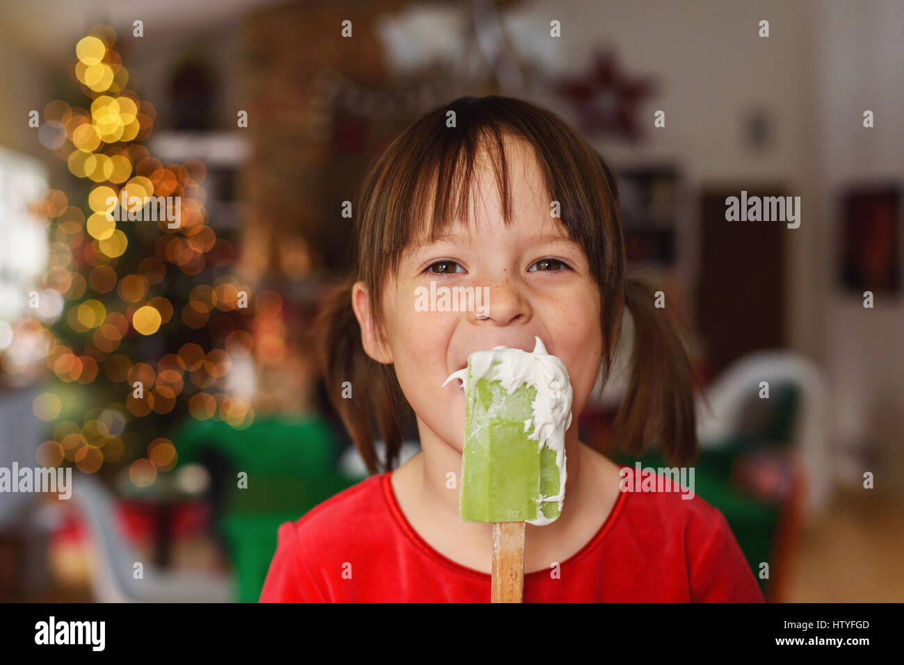 Girl licking frosting off a spatula Stock Photo