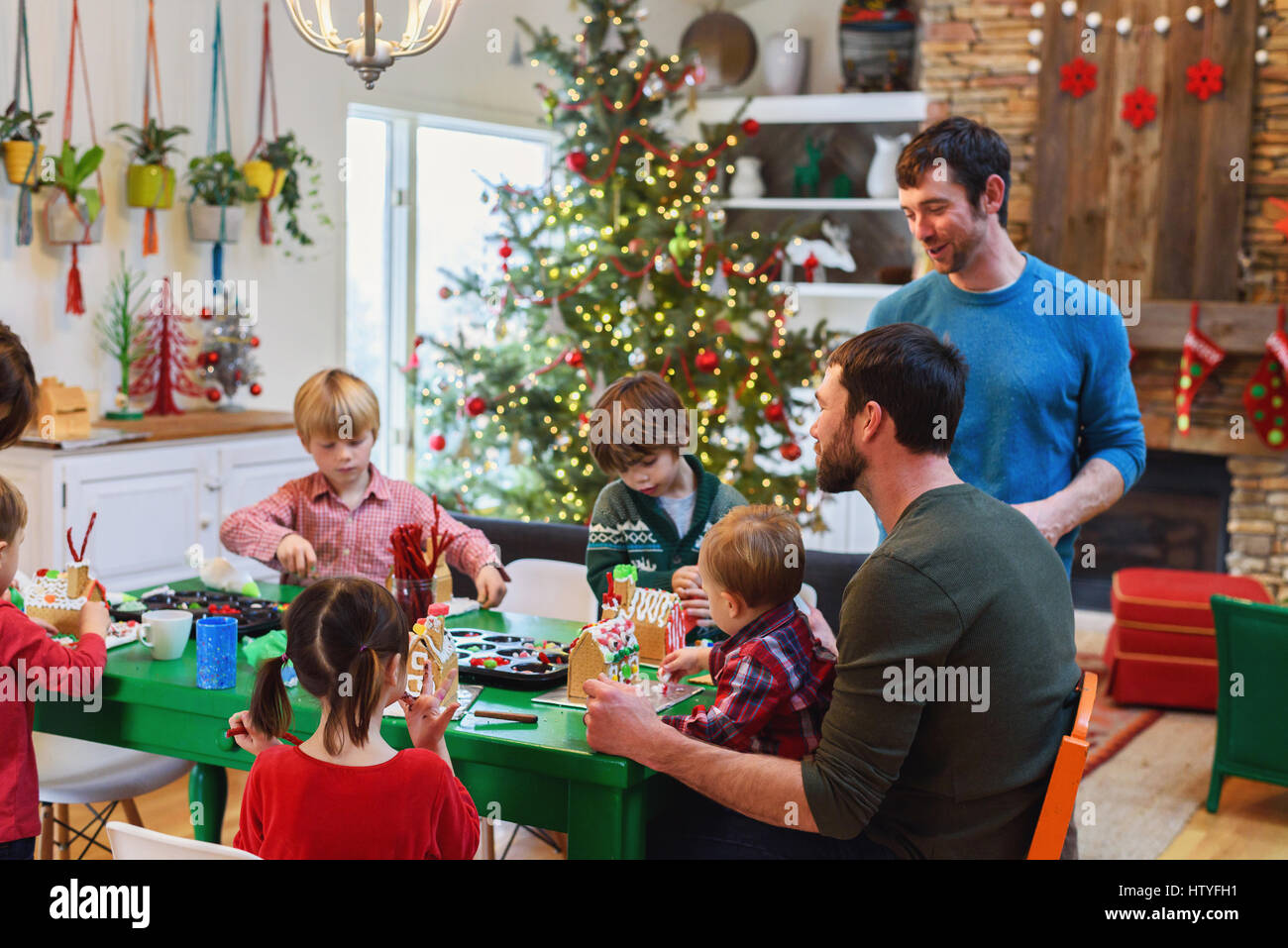 Family decorating gingerbread houses Stock Photo