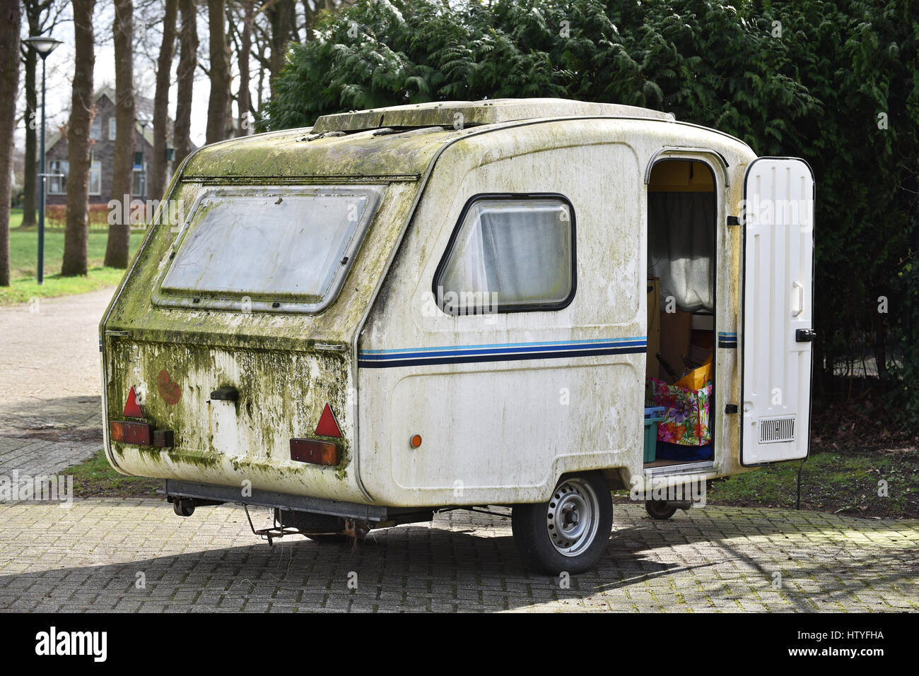 Dirty old-fashioned Polish-made caravan of polyester on a camping site in The Netherlands Stock Photo