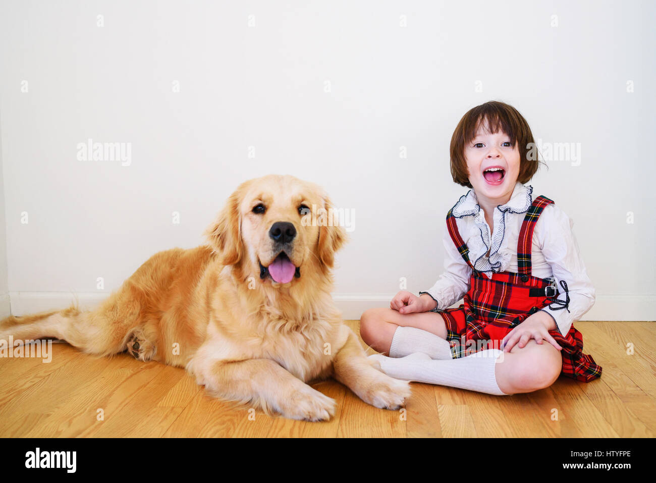 Girl sitting on floor with her golden retriever dog Stock Photo - Alamy
