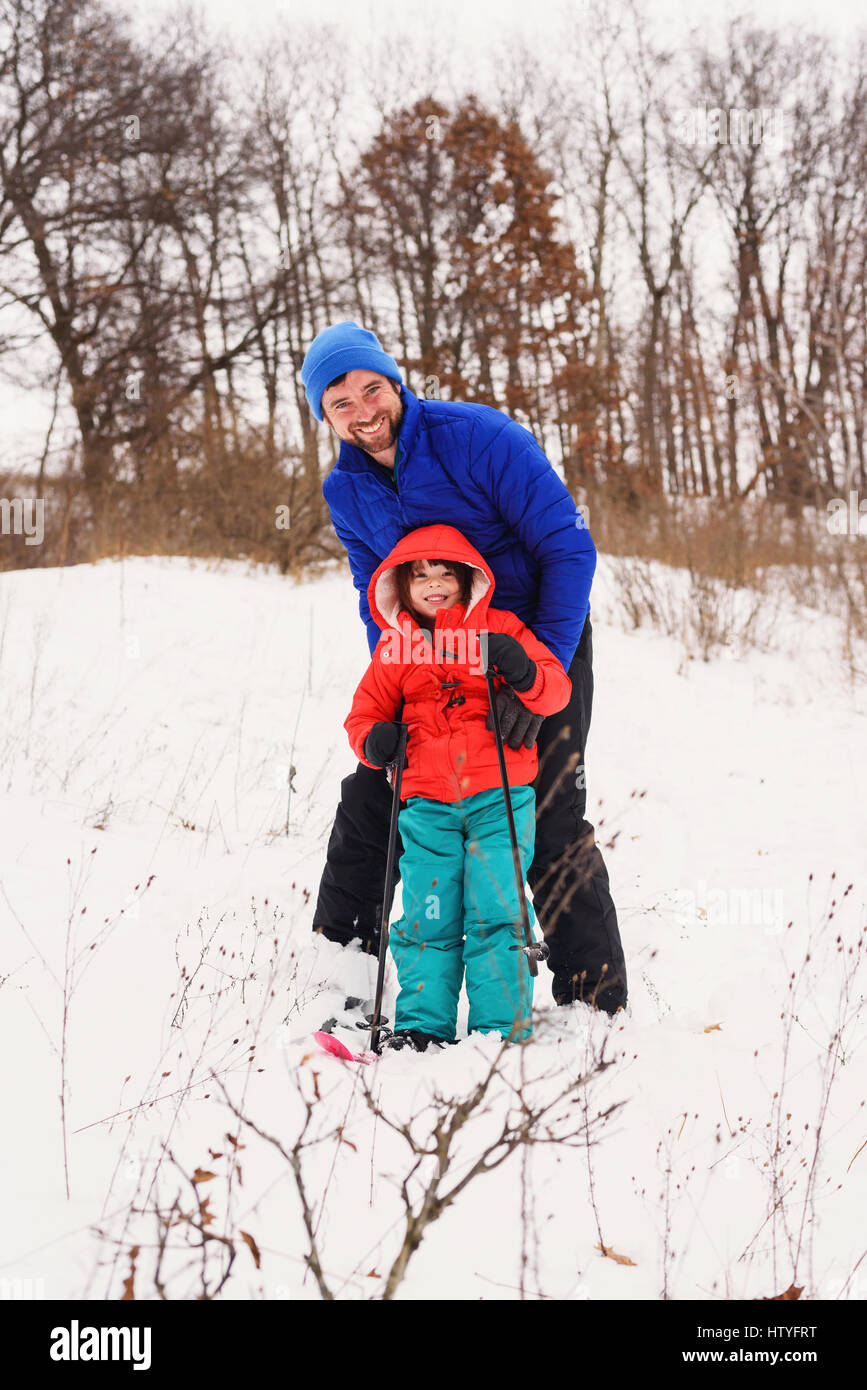 Father teaching his daughter to ski Stock Photo