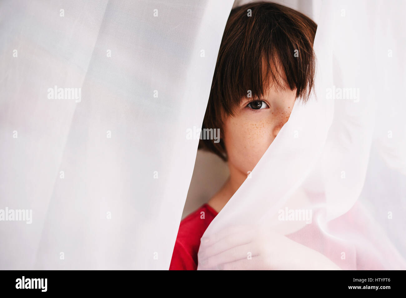 Girl hiding behind a curtain Stock Photo Alamy