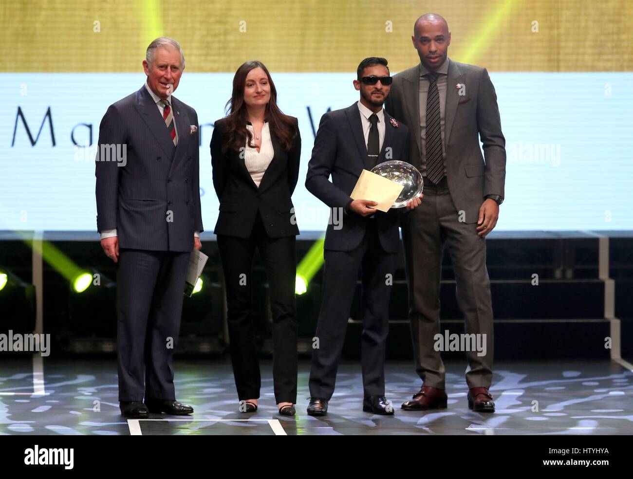 The Prince of Wales (left) on stage with the winner of the Mappin and Webb Young Ambassador of the Year Award Efaz Ahmed (2nd right) with Thierry Henry (right) during the Prince's Trust Celebrate Success Awards at the London Palladium. Stock Photo