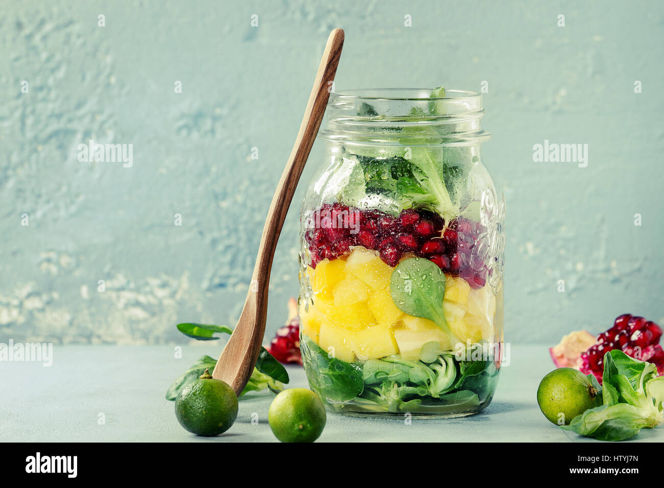 Salads in mason jar. Fruit salad with mango, pomegranate, greens ...