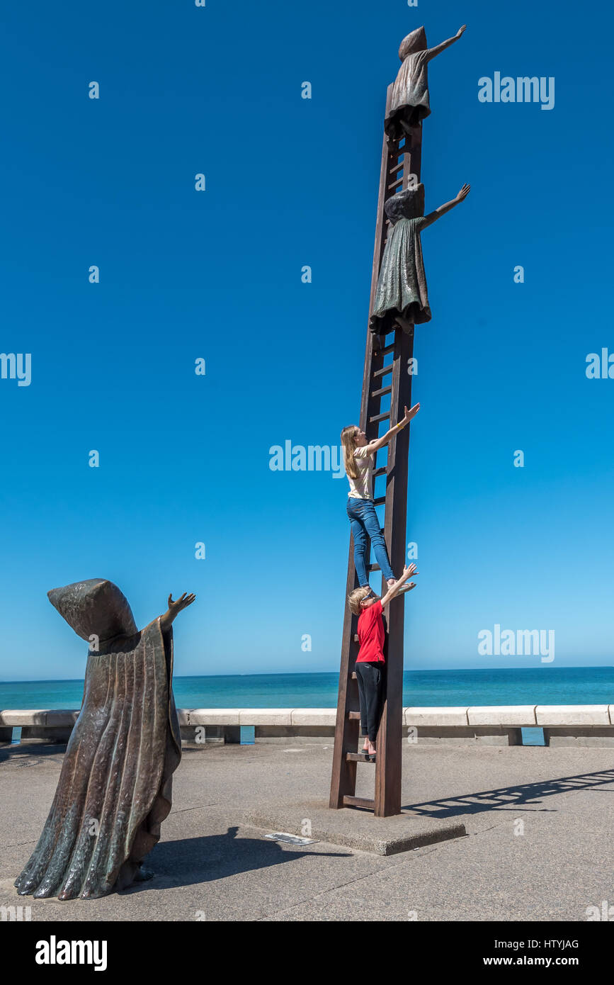 Searching for Reason sculpture on the Malecon in Puerto Vallarta with real people / kids climbing ladder posing for photo (Sergio Bustamante). Stock Photo