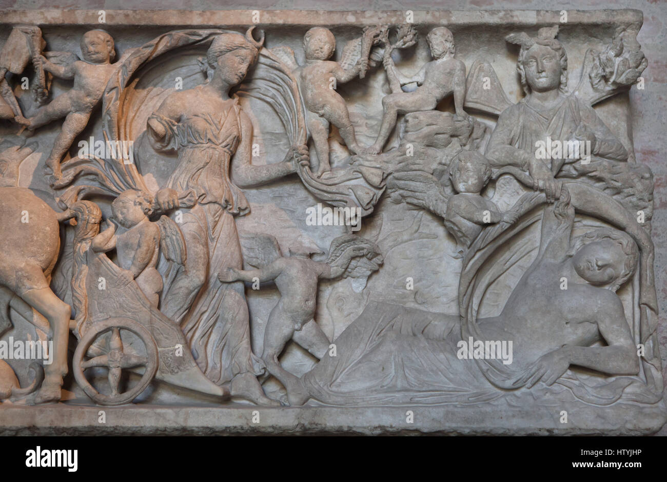 Selene and Endymion on Mount Latmus. Front side of a Roman sarcophagus from about 180 AD on display in the Glyptothek Museum in Munich, Bavaria, Germany. The moon goddess Selene is depicted as she arrives on her chariot surrounded by Erotes on the Mount Latmos and sees her lover Endymion in eternal sleep. The winged god of sleep Hypnos is depicted as he repands on Endymion sleeping liquid. The mountain god of the Latmos Mountains is depicted sitting on a rock on top. Stock Photo