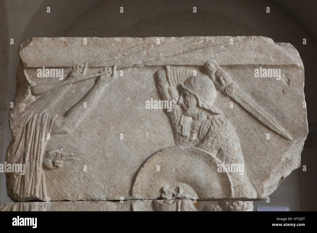 Gladiator fight. Relief from about 30 BC perhaps a part of a funerary monument on display in the Glyptothek Museum in Munich, Bavaria, Germany. Two trumpet players proclaim the victory of the duel. The winner raises his sword and awaits the verdict of the spectators, who decide life or death for the loser. Stock Photo