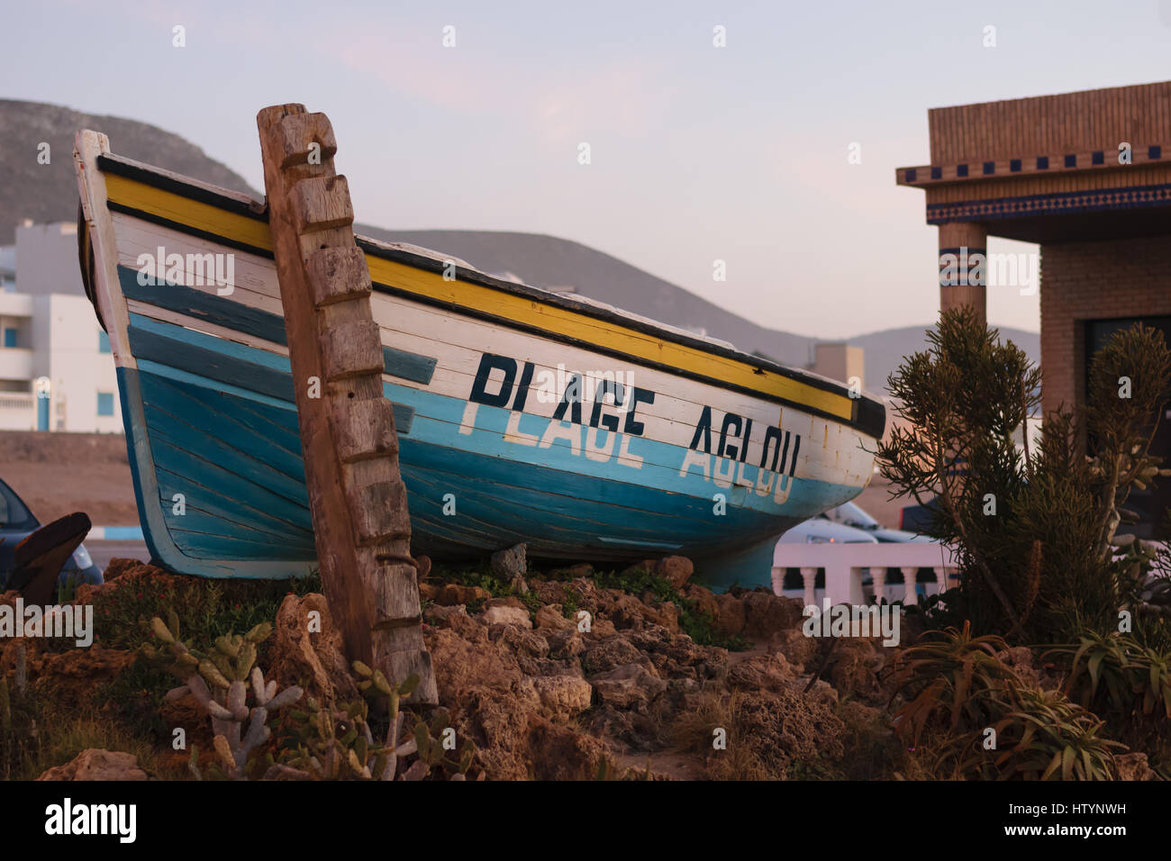 A boat a the entrance to the beach of Aglou in Morocco wiht the words Aglou Plage written on it. Stock Photo