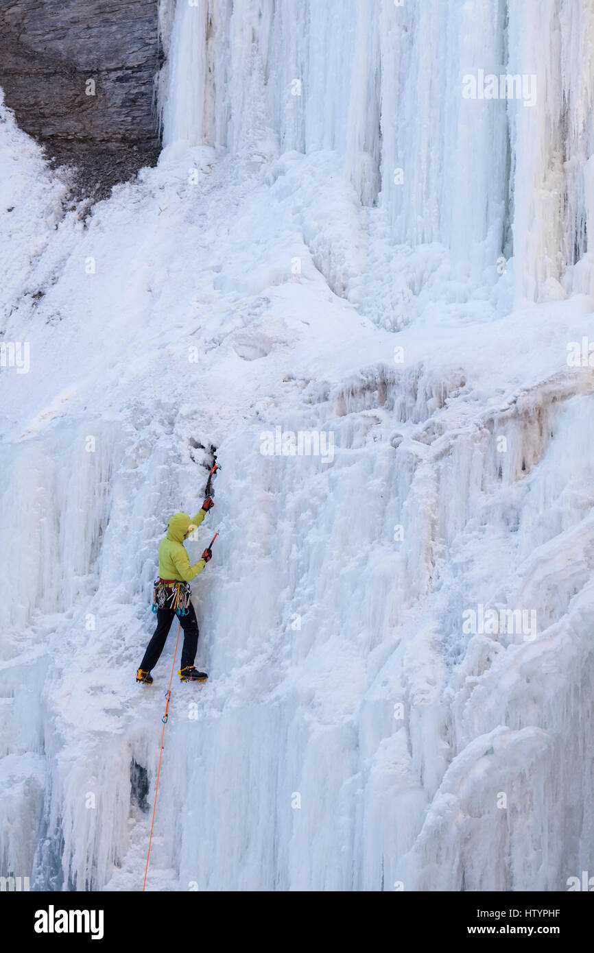 An ice climber climbing the frozen Buttermilk Falls in Hamilton, Ontario, Canada. Stock Photo