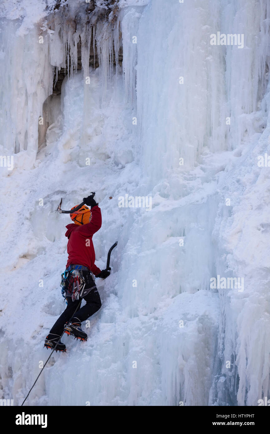 An ice climber climbing the frozen Buttermilk Falls in Hamilton, Ontario, Canada. Stock Photo
