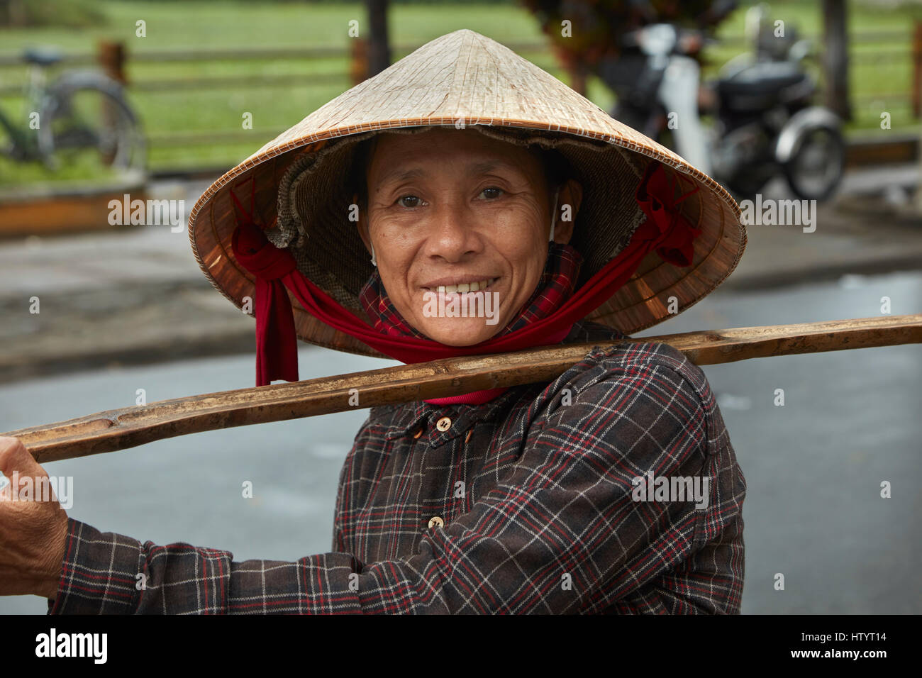 Vietnamese woman carrying produce on a bamboo yoke, Hoi An (UNESCO World Heritage Site), Vietnam Stock Photo