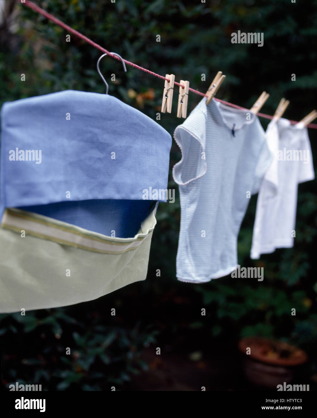 Close-up of a home made peg bag on a washing line with tee shirts Stock Photo