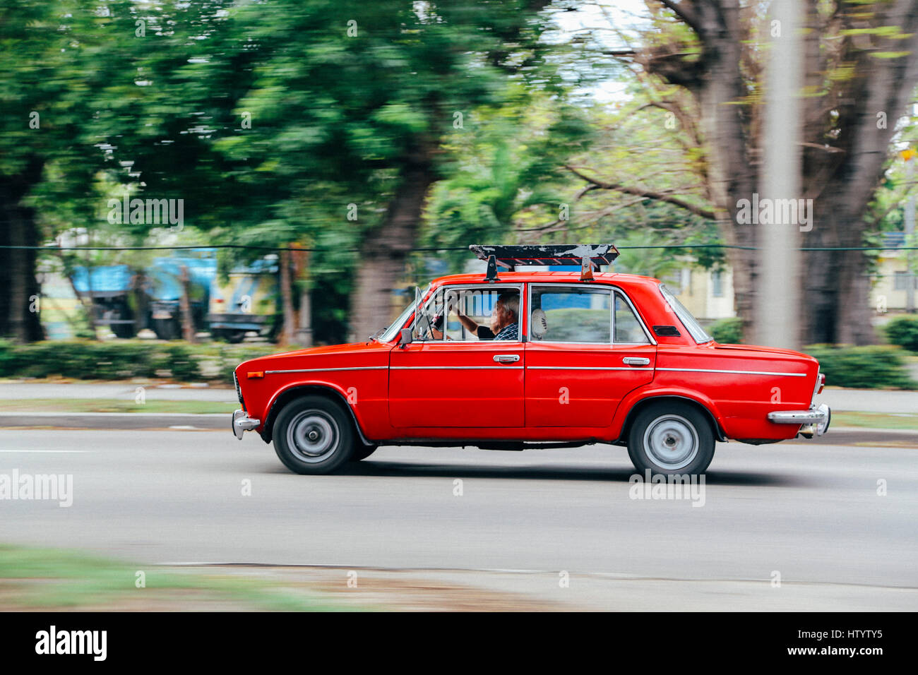 An old red Lada car in motion on a road in Havana, Cuba Stock Photo