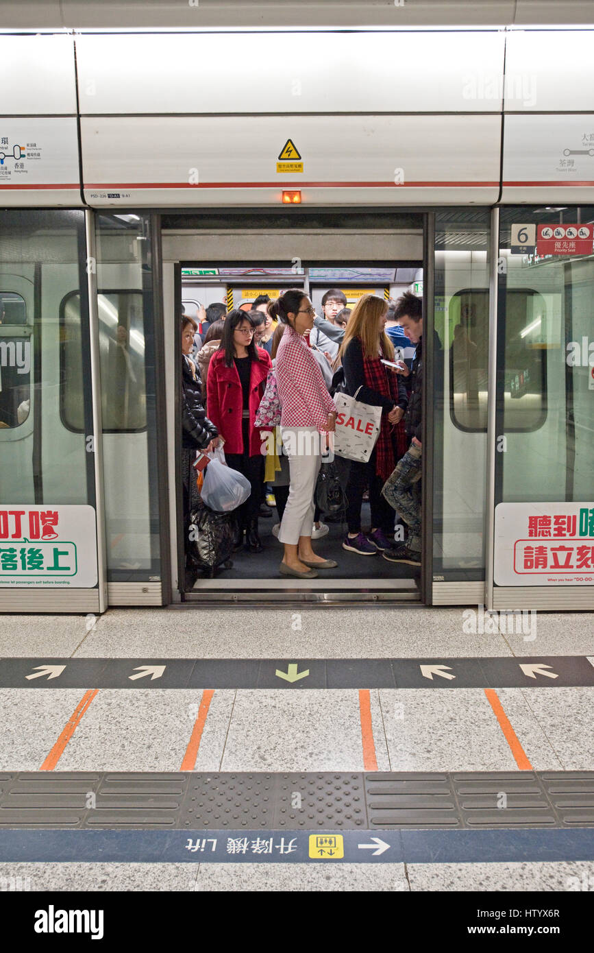 Commuters onboard waiting for the train to depart on the MTR - underground railway system in Hong Kong. Stock Photo