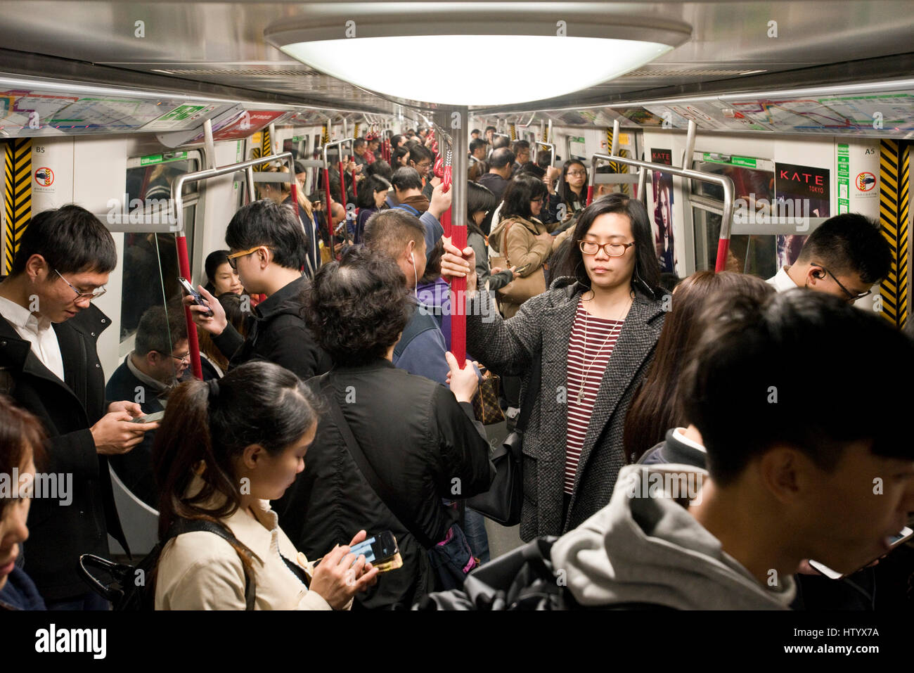 A very busy and crowded underground train with people on the MTR in Hong Kong. Stock Photo