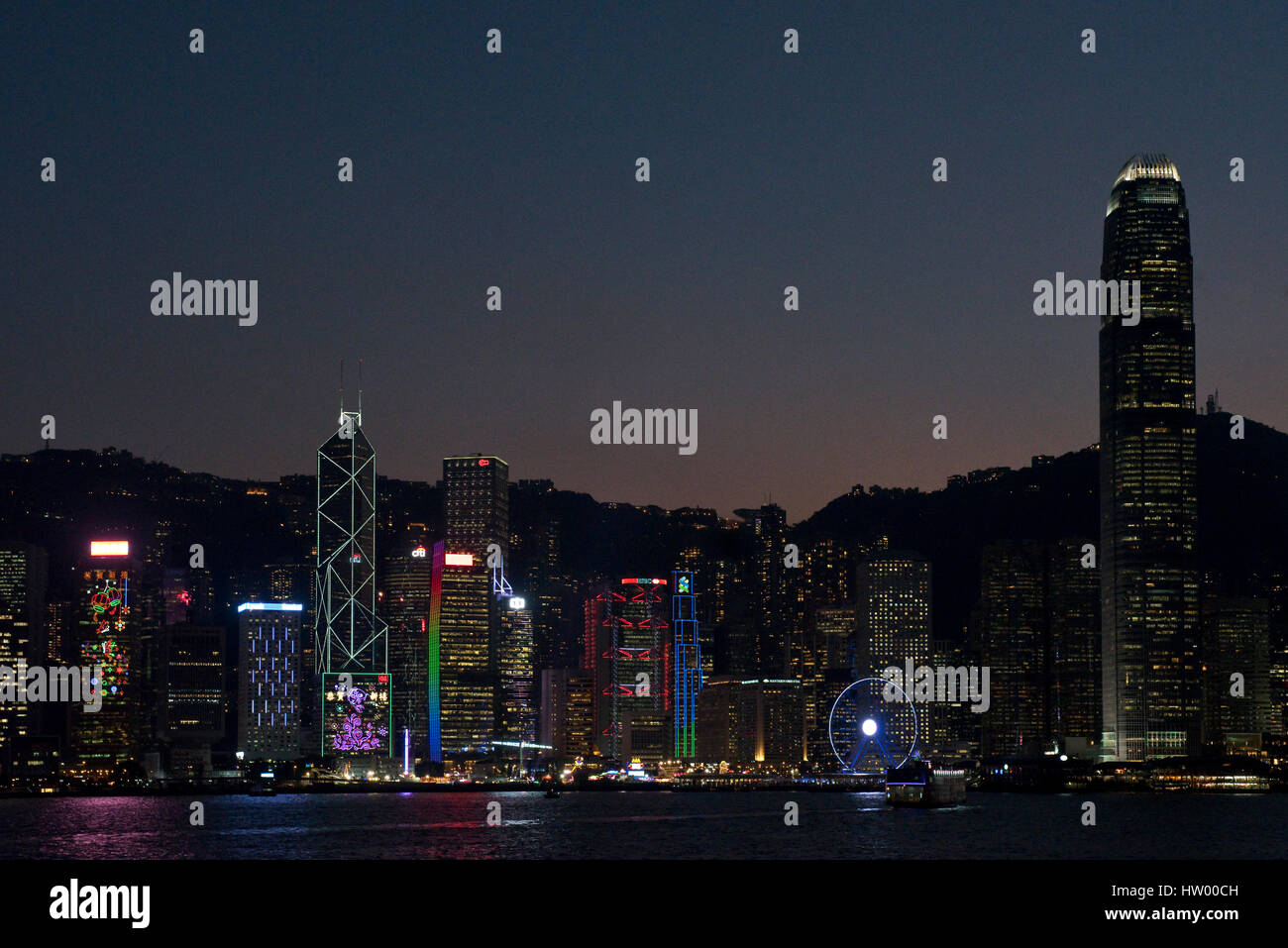 A colourful cityscape view of the buildings along Hong Kong Island from the Kowloon Public Pier at night. Stock Photo
