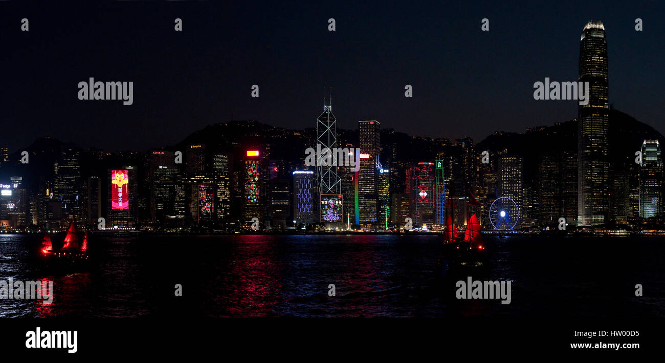 A 2 picture stitch panoramic colourful cityscape view of the buildings along Hong Kong Island from the Kowloon Public Pier at night. Stock Photo