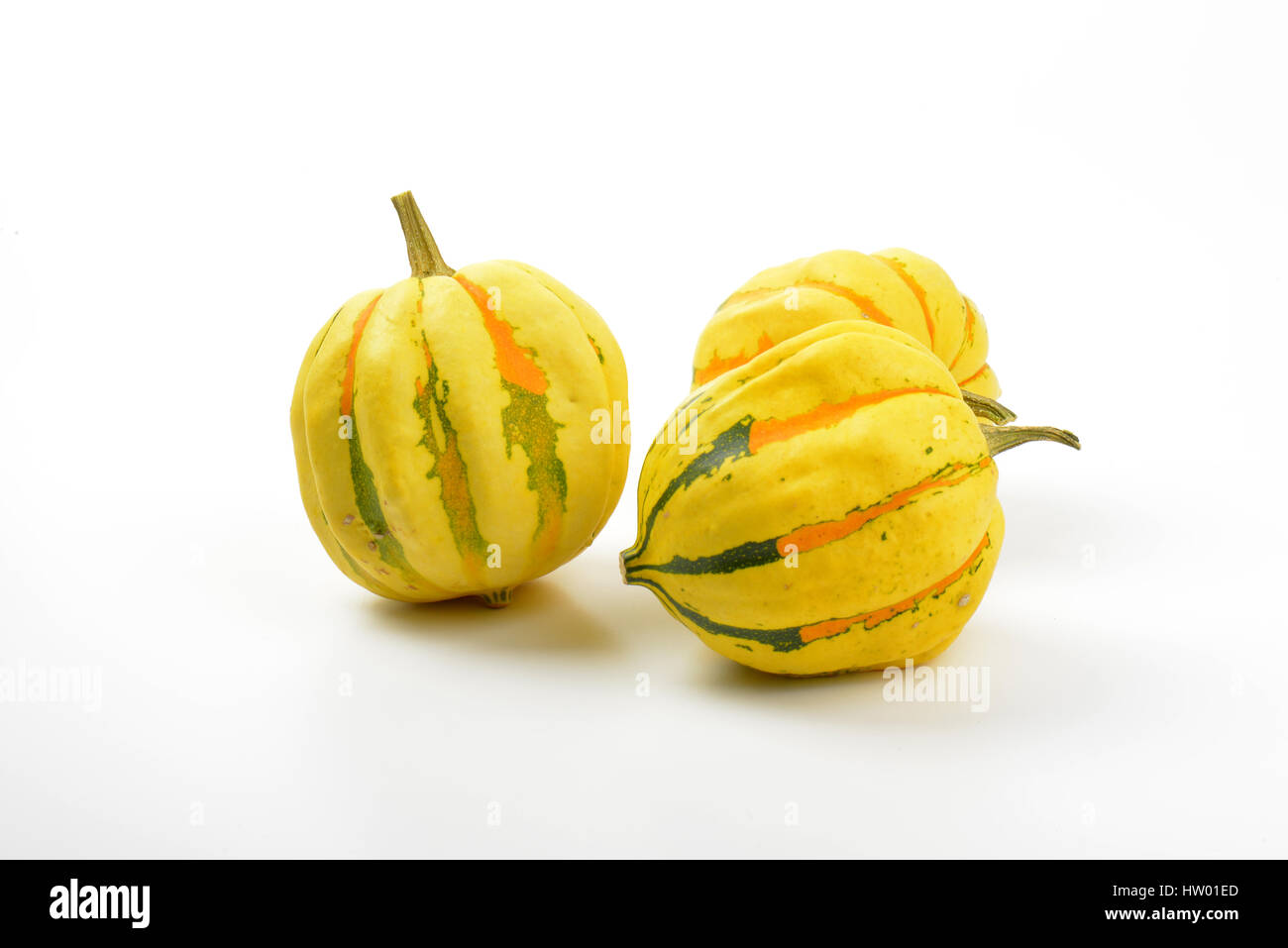 three small striped pumpkins on white background Stock Photo - Alamy