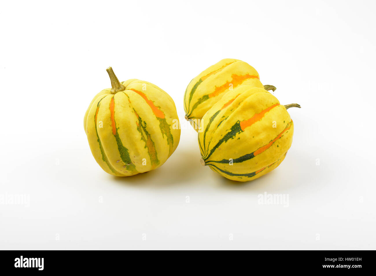 three small striped pumpkins on white background Stock Photo - Alamy